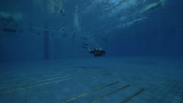 Diver student with scuba tank and scuba mask learning to deep diving in pool
