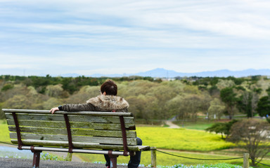 Fototapeta na wymiar One person sitting on bench in the park, , Hitachi Seaside Park, Japan