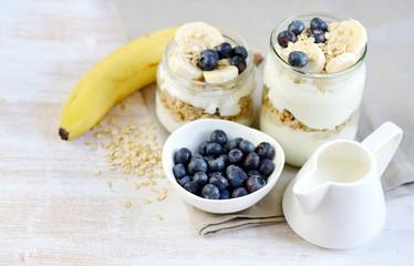 Vitamin Healthy Breakfast Yogurt with Oat Flakes, Banana and Blueberries White Wooden Background Porridge Glass Jar Useful Food