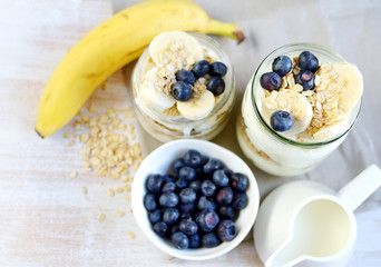 Vitamin Healthy Breakfast Yogurt with Oat Flakes, Banana and Blueberries White Wooden Background Porridge Glass Jar Useful Food