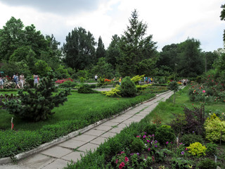 Ukraine, Zaporizhia - June 24, 2017: Excursion on Zaporizhzhya city children's botanical garden. Beautiful spring - summer garden with stone paths and flower beds and people admire colorful flowers