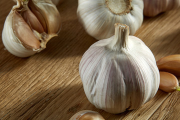 Garlic close up on wooden plate on rustic background, shallow depth of field, selective focus, macro