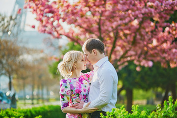 Couple in front of the Eiffel tower on a spring day in Paris, France