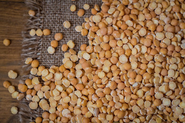 Peas on a wood background and burlap top view