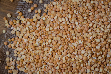 Peas on a wood background and burlap top view