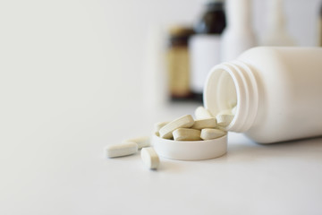 Vitamins, pills in a white plastic bottle on a white background. Against the background of drugs