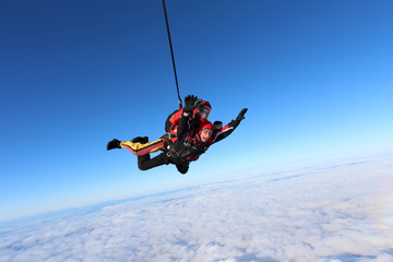 Skydiving. Tandem jump in the blue sky.
