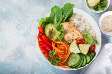 vegan lunch bowl salad with roasted tofu cheese, avocado, rice, cucumber, bell pepper, carrot and pak choi