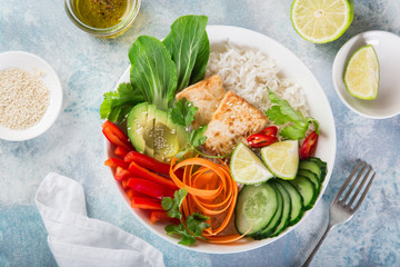 vegan lunch bowl salad with roasted tofu cheese, avocado, rice, cucumber, bell pepper, carrot and pak choi