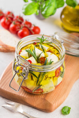 marinated feta cheese with olive oil, spicy herbs, garlic and chili pepper in jar