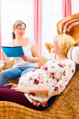 Midwife consulting pregnant woman for pregnancy and childbearing in practice