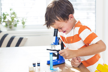 young boy  is working with the microscope