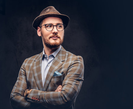 Studio portrait of a bearded hipster in hat and glasses wearing 