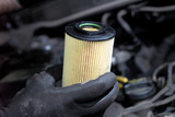 mechanic in the hand, remove car oil filter