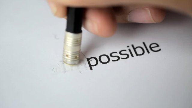 Changing the word impossible to possible with a pencil eraser - business concept