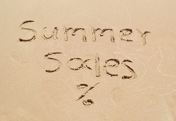 summer sales written on sand - seasonal discount shopping
