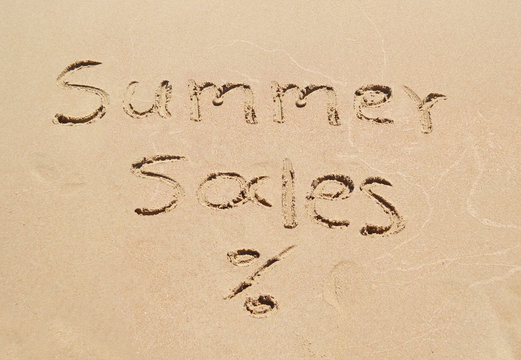 summer sales written on sand - seasonal discount shopping
