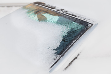 Parked cars covered with a thick layer of snow. Consequences of a heavy snowfall.
