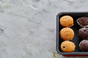Fresh baked chocolate muffins on a cookie sheet, top view, close-up, selective focus