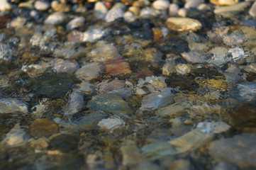 pebble stones on the sea beach, the rolling waves of the sea with foam