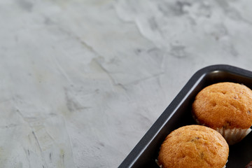 Fresh baked chocolate muffins on a cookie sheet, top view, close-up, selective focus