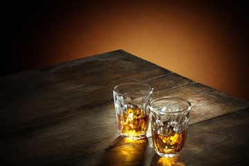 view of two glasses of  whiskey on color background. 