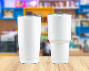 Stainless steel tumbler mug on wooden backdrops. Template of insulated mug for design.
