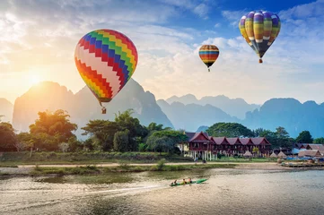  Hot air balloon over Nam Song river at sunset in Vang vieng, Laos. © tawatchai1990