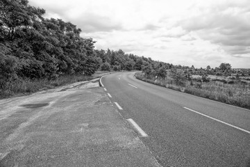 Monochrome image of a curving country road