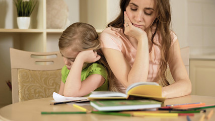 Sad mother and daughter having conflict, bored girl refusing to do homework