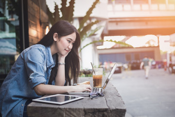 Young asian business woman working and enjoy online social connection on laptop computer at coffee shop, lifestyle people