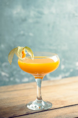 Sweet cocktail with peach liquor and physalis. Shallow depth of field. Selective focus.