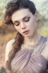 Naklejka premium Portrait of a Young woman in liliat dress in a park. Glamour fashion bride concept