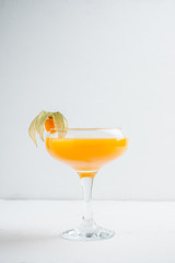 Sweet cocktail with peach liquor and physalis. Shallow depth of field. Selective focus.