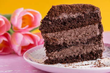 bouquet of tulips on the table with a piece of chocolate cake
