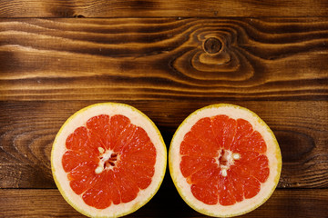 Fototapeta na wymiar Halves of ripe grapefruit on wooden table