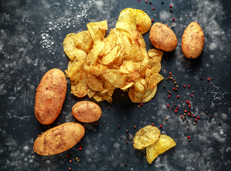 cooked creamy peppercorn potato chips, snack crisps with sea salt on stone board with marble pestle...