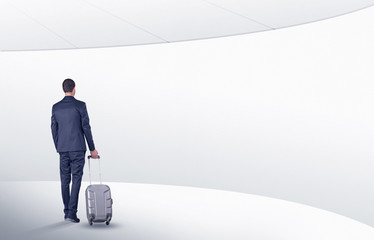 Businessman with suitcase walking in waiting room