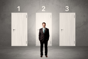 Businessman thinking in front of three doors