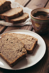 Fototapeta na wymiar Banana bread and cup of coffe on wooden background. Breakfast concept.
