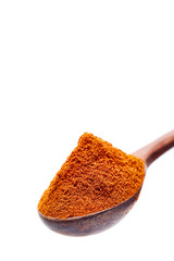 Top view of a wooden spoon full of paprica isolated on white background, shallow depth of field.