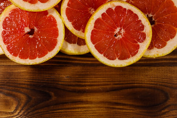 Fototapeta na wymiar Sliced grapefruits on wooden table. Top view, copy space