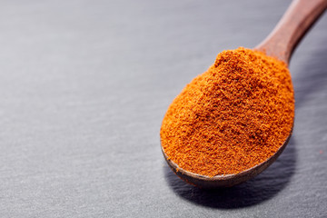 Shichimi pepper in Wooden spoon on black plate,