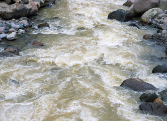 Mountain river with stones. Fast water current. Water photo texture.