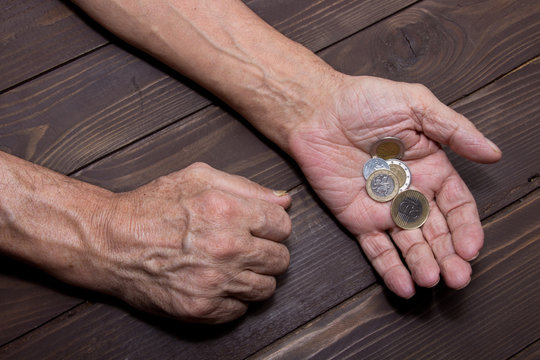 Begging for money. Elderly person Hands of beggar with few coins. The concept of poverty