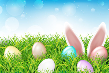 Colorful Easter eggs and rabbit ears sticking out of the grass. Spring landscape with blue sky. Greetig card template. Spring easter design