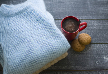background with sweaters and red cup of cacao, cookie