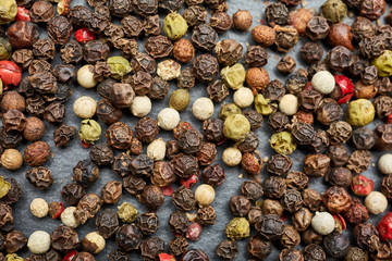 Mix of grind black pepper and black, white, red and yellow peppercorn. Selective focus.