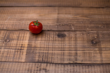 Lonely cherry tomato on wooden table. Place for text or design