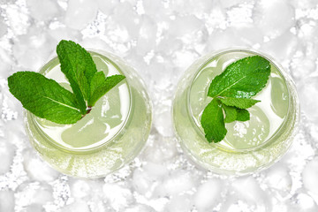 Refreshing drink with mint and ice cubes in large wine glasses